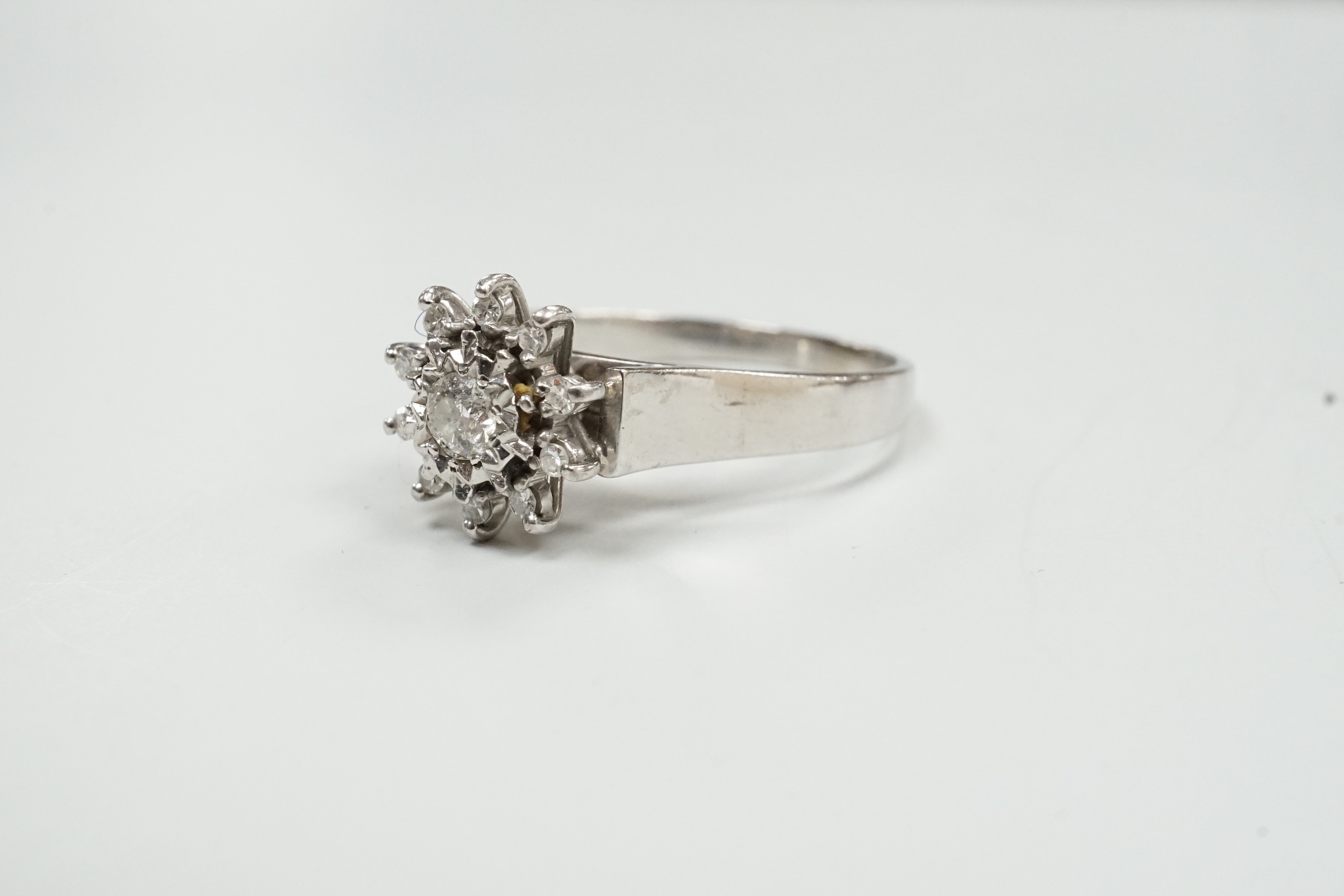 A modern 18ct white metal and diamond cluster set flower head ring, size U, gross weight 5 grams.